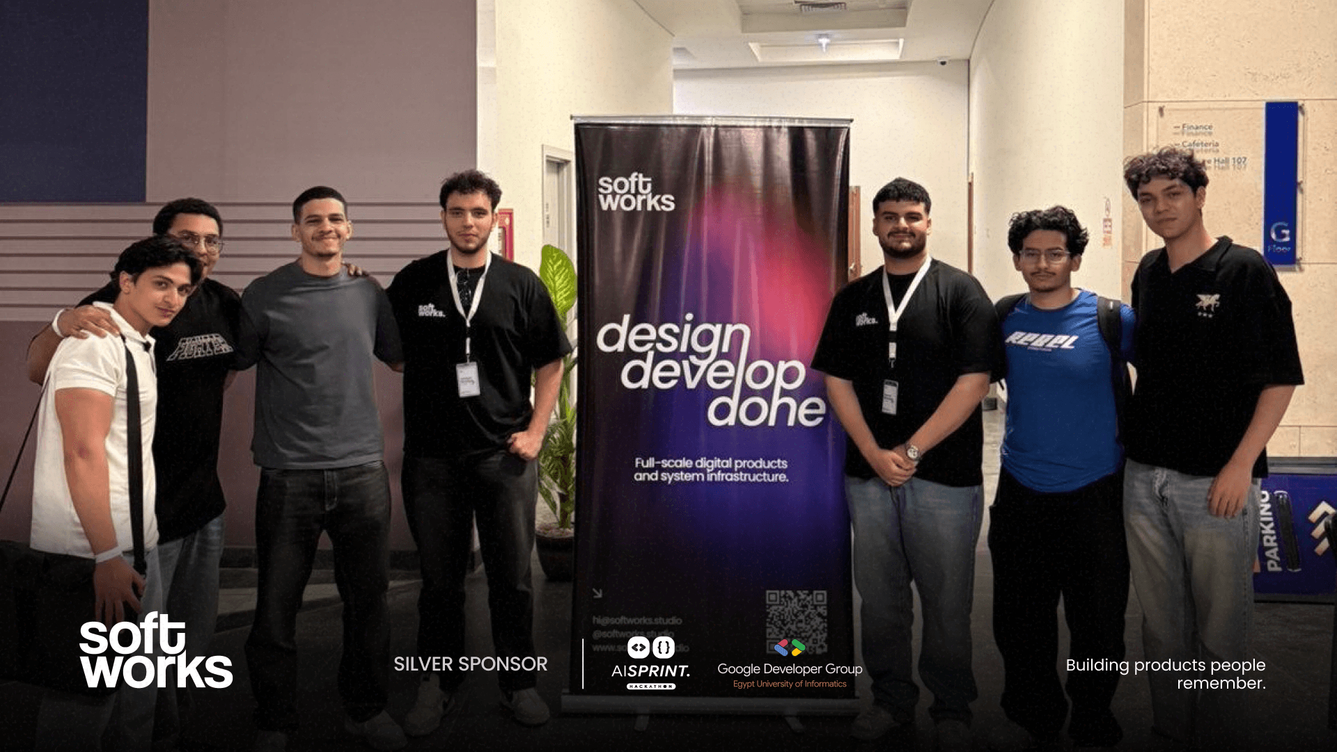 Softworks team with students beside the studio banner